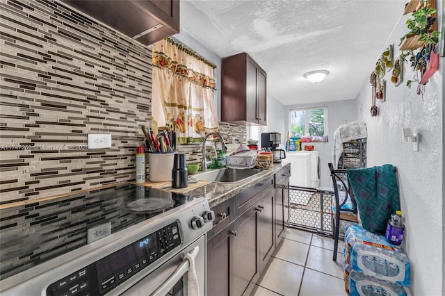 kitchen featuring light tile patterned floors, dark brown cabinetry, a sink, electric stove, and backsplash