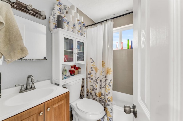 full bath featuring toilet, shower / bathtub combination with curtain, and vanity