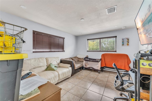 living area featuring light tile patterned floors, visible vents, and a textured ceiling