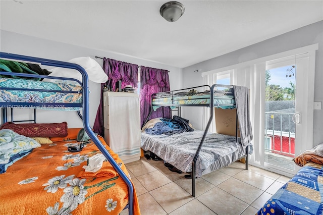 bedroom with light tile patterned floors and access to exterior