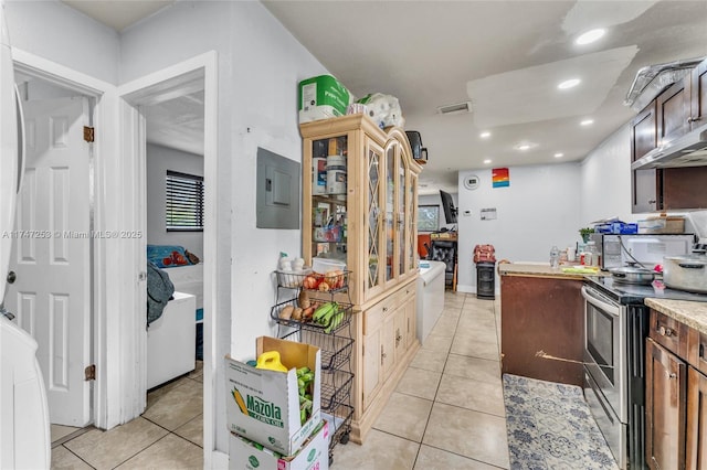 kitchen with light countertops, electric stove, electric panel, and light tile patterned floors