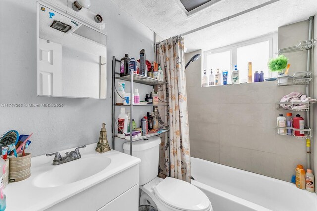 full bath featuring shower / bath combination with curtain, vanity, toilet, and a textured ceiling