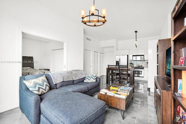 living room with concrete flooring and an inviting chandelier