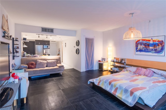 bedroom with rail lighting, baseboards, visible vents, and stainless steel refrigerator