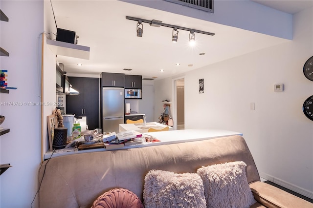 kitchen featuring baseboards, visible vents, a peninsula, stainless steel appliances, and track lighting