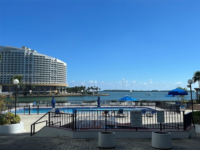 pool featuring a water view and fence