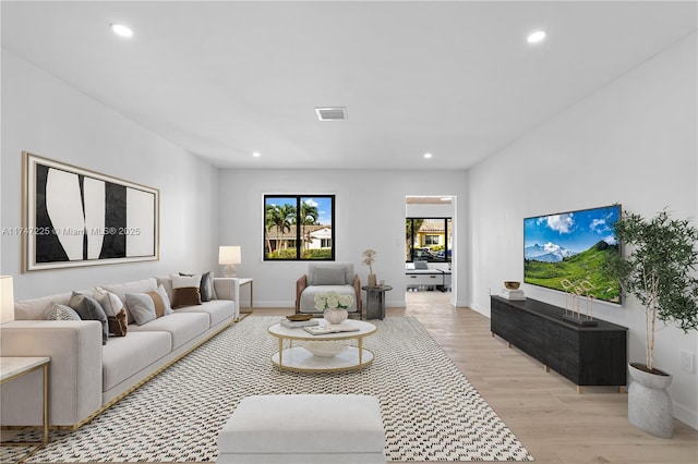 living area featuring light wood-style flooring, visible vents, and recessed lighting