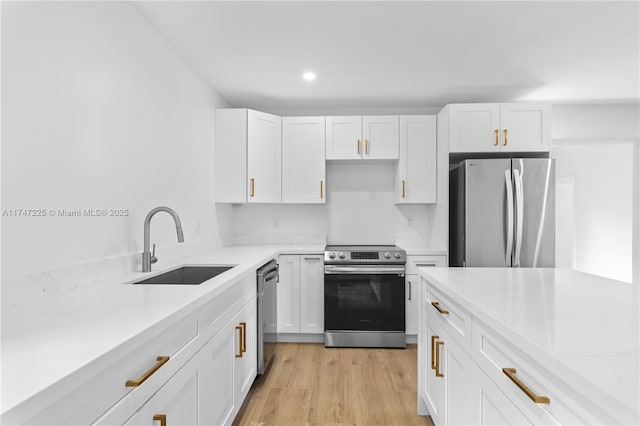 kitchen featuring white cabinets, stainless steel appliances, and a sink