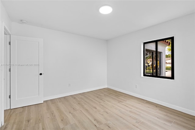 empty room featuring light wood-style flooring and baseboards