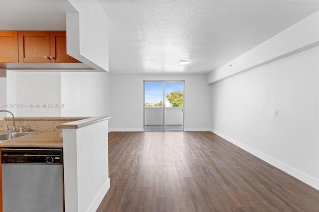 unfurnished living room with dark hardwood / wood-style flooring, sink, and a textured ceiling