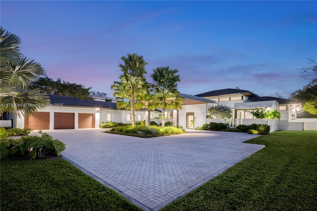 view of front of house featuring a garage and a lawn