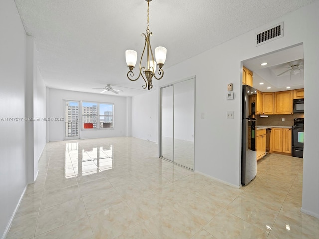 interior space featuring a textured ceiling and ceiling fan with notable chandelier