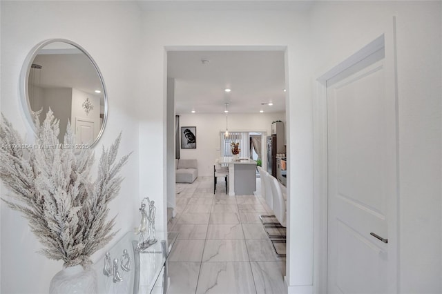 corridor with marble finish floor and recessed lighting