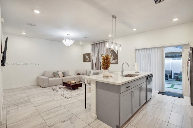 kitchen with a sink, open floor plan, light countertops, stainless steel dishwasher, and gray cabinets