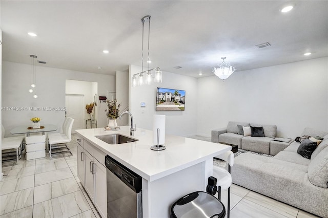 kitchen featuring marble finish floor, light countertops, open floor plan, a sink, and dishwasher