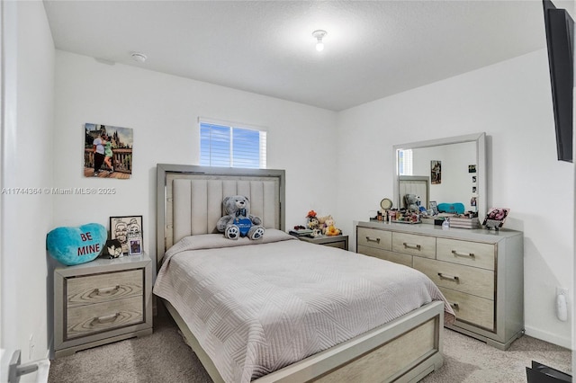 bedroom featuring light carpet and baseboards