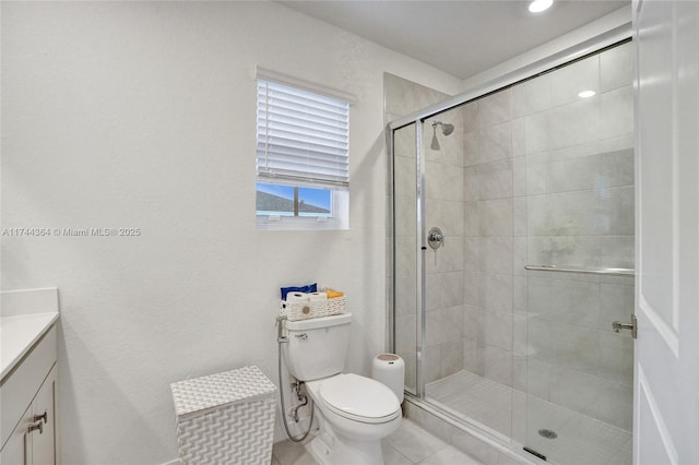 bathroom featuring toilet, a shower stall, vanity, and tile patterned floors