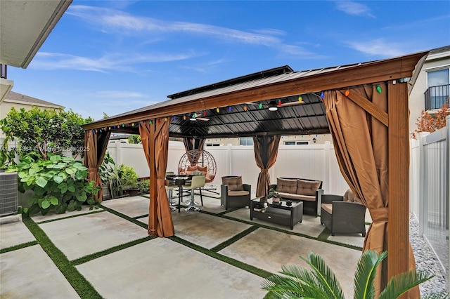 view of patio / terrace with a fenced backyard, outdoor lounge area, cooling unit, and a gazebo