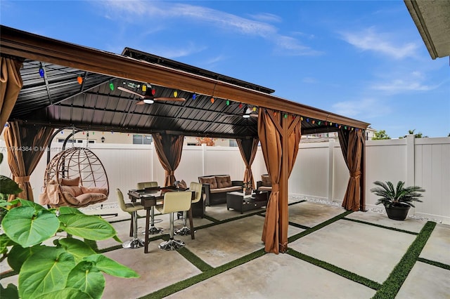 view of patio / terrace with a fenced backyard, ceiling fan, an outdoor living space, and a gazebo