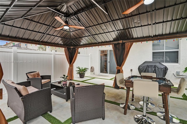 view of patio featuring a ceiling fan, a fenced backyard, outdoor dining area, a gazebo, and an outdoor living space