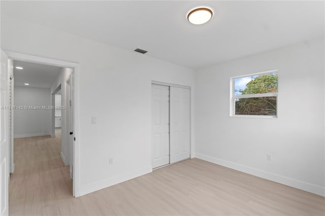 unfurnished bedroom with a closet and light hardwood / wood-style flooring