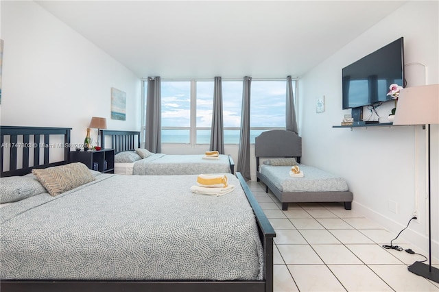 bedroom with light tile patterned flooring and a wall of windows