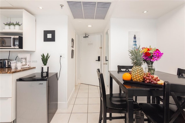 kitchen with light tile patterned flooring, white cabinetry, and stainless steel appliances