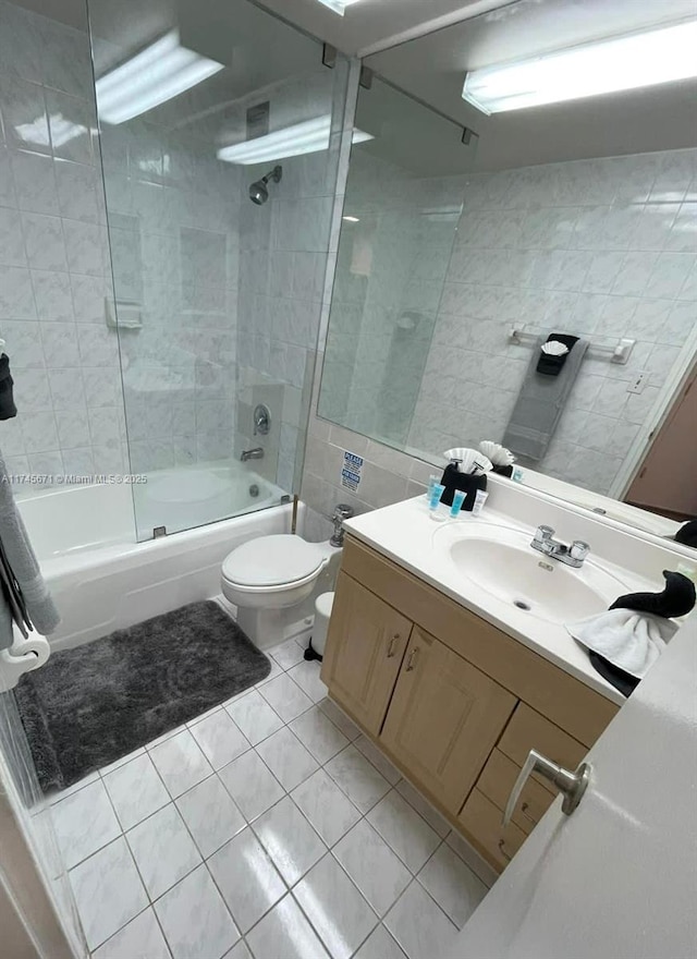 full bathroom featuring tile walls, vanity, tiled shower / bath combo, toilet, and tile patterned floors