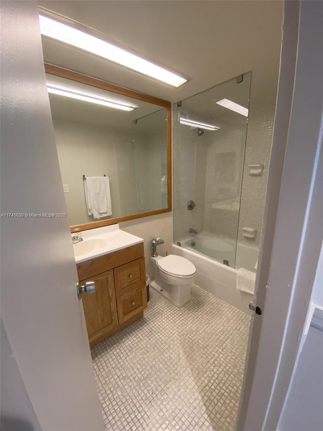 full bathroom featuring tile patterned flooring, toilet, vanity, and tiled shower / bath