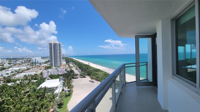 balcony with a water view and a beach view