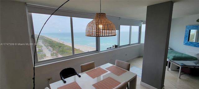 tiled dining space featuring a water view and a view of the beach