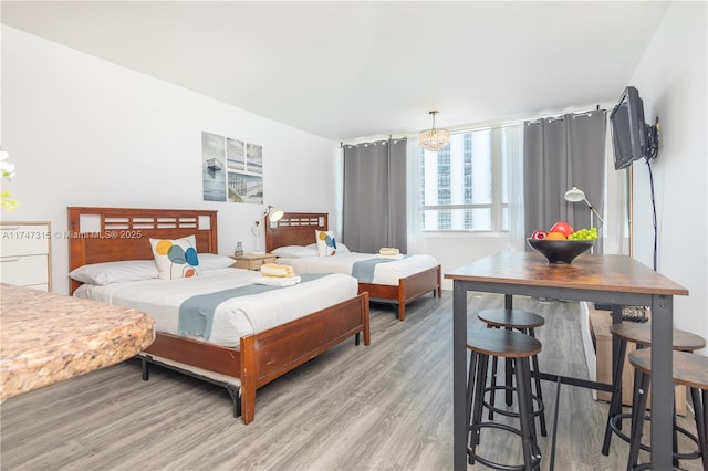 bedroom featuring an inviting chandelier and hardwood / wood-style floors