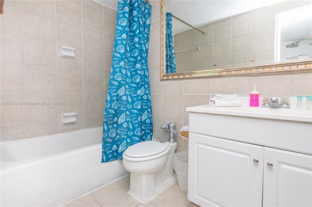 full bathroom featuring tile patterned floors, toilet, shower / bath combination with curtain, tile walls, and vanity