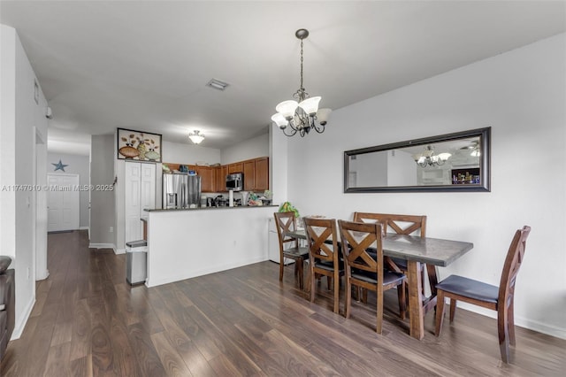 dining area with a chandelier and dark hardwood / wood-style floors