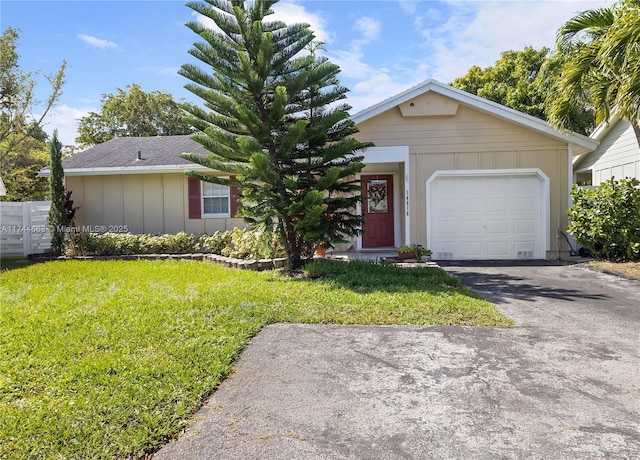 single story home featuring an attached garage, a front lawn, aphalt driveway, and board and batten siding