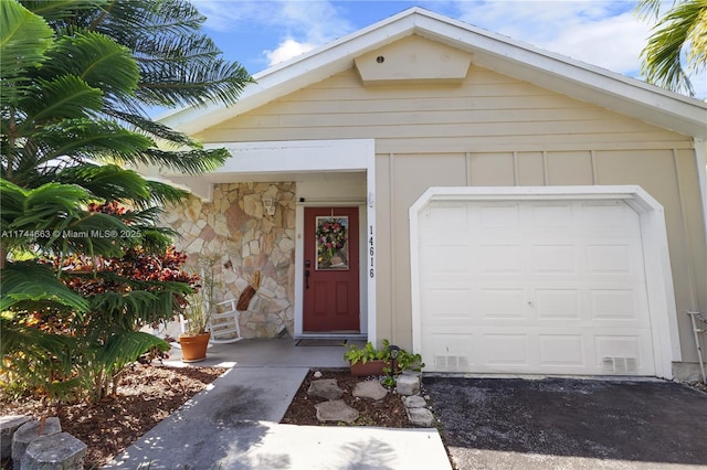 exterior space with stone siding and driveway