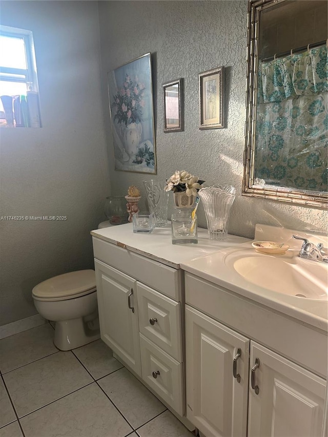 bathroom with toilet, vanity, tile patterned flooring, and a shower with curtain