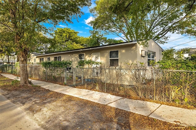 ranch-style home with a fenced front yard and stucco siding