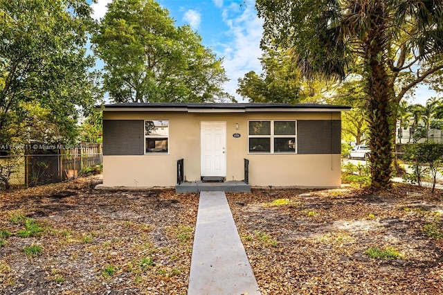 bungalow-style house with fence and stucco siding