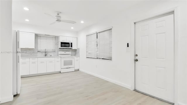 kitchen with light countertops, white appliances, white cabinetry, and light wood-style floors