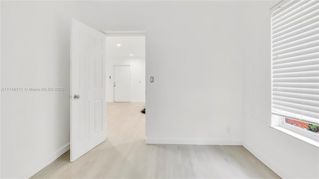 empty room featuring light wood-type flooring and baseboards