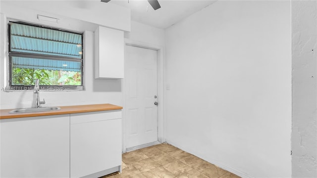 interior space with ceiling fan and a sink