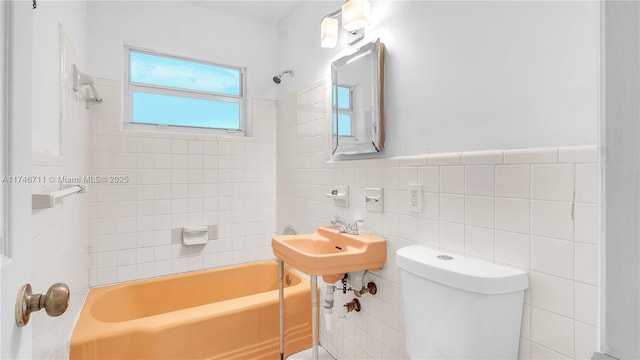 full bath with toilet, a wainscoted wall, shower / washtub combination, and tile walls