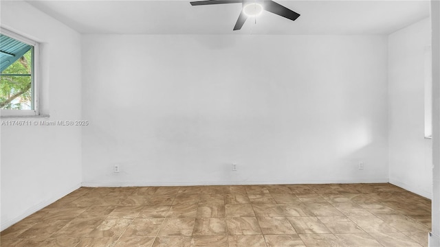 empty room featuring ceiling fan and baseboards