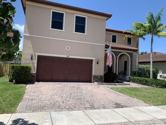 mediterranean / spanish-style home featuring a front yard and a garage