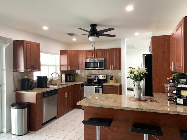 862 NW 132nd Ct, Miami, FL 33182 - kitchen featuring a breakfast bar area, a sink, ceiling fan, a peninsula, and appliances with stainless steel finishes