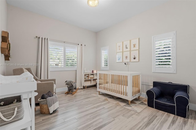 bedroom featuring hardwood / wood-style floors and a nursery area