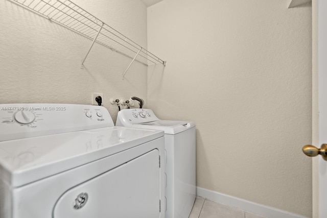 washroom featuring washer and clothes dryer and light tile patterned floors