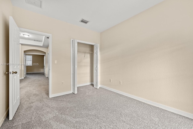 unfurnished bedroom featuring a closet and light colored carpet