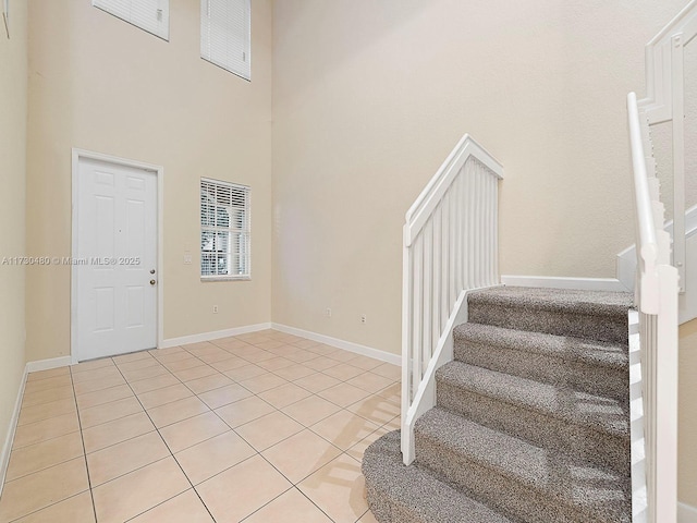 tiled foyer featuring a towering ceiling